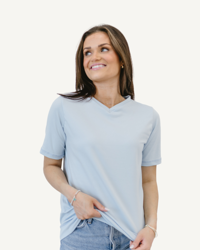 Woman in neutral shirt and jeans, standing confidently. Favorite Tee.