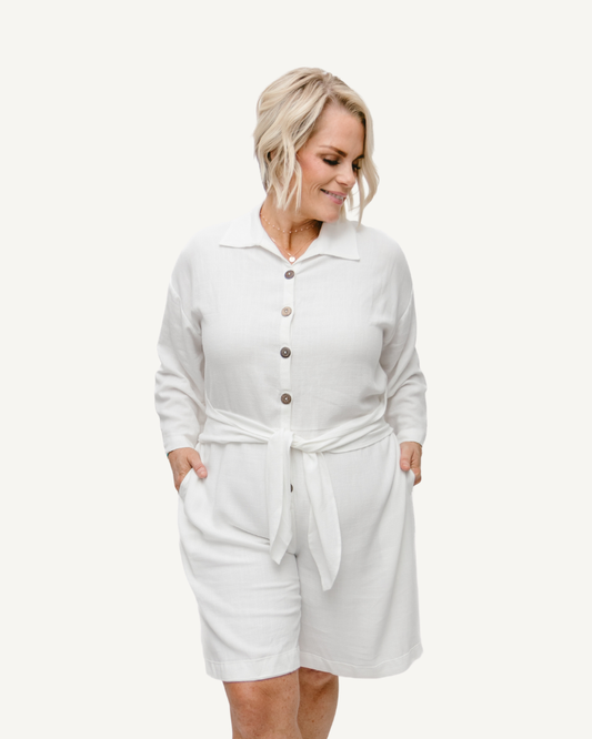 A white linen romper with long sleeves and a tie waist. Perfect for a casual summer look.