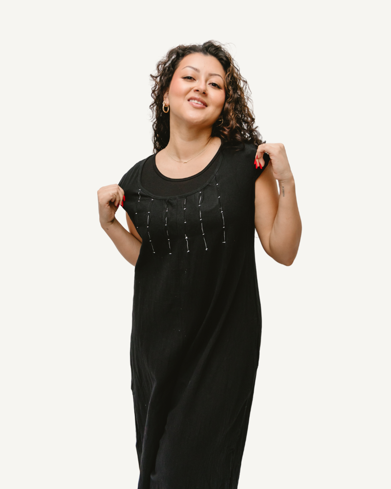 A woman in a black dress with a smile on her face, wearing a Short Sleeve Jumper.