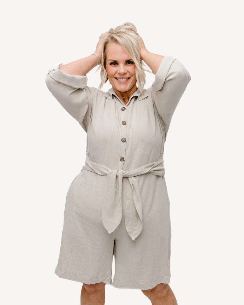 A Gray  linen romper with long sleeves and a tie waist. Perfect for a casual summer look.