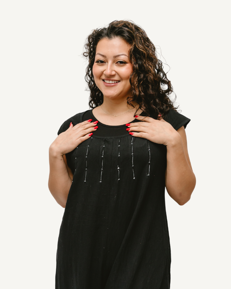 A woman in a black dress with a smile on her face, wearing a Short Sleeve Jumper.