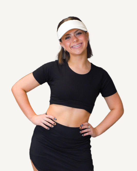 Woman in black crop top and skirt.