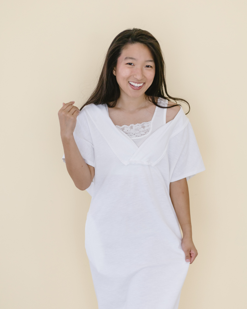 woman in a white crop top and jeans, wearing a Peekaboo Short Sleeve Halftee with lace inset.