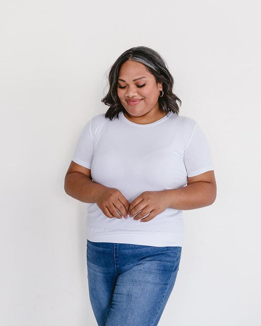 A woman wearing a white t-shirt and jeans, featuring a Crew Neck Boyfriend Full-Length - Layering Top.