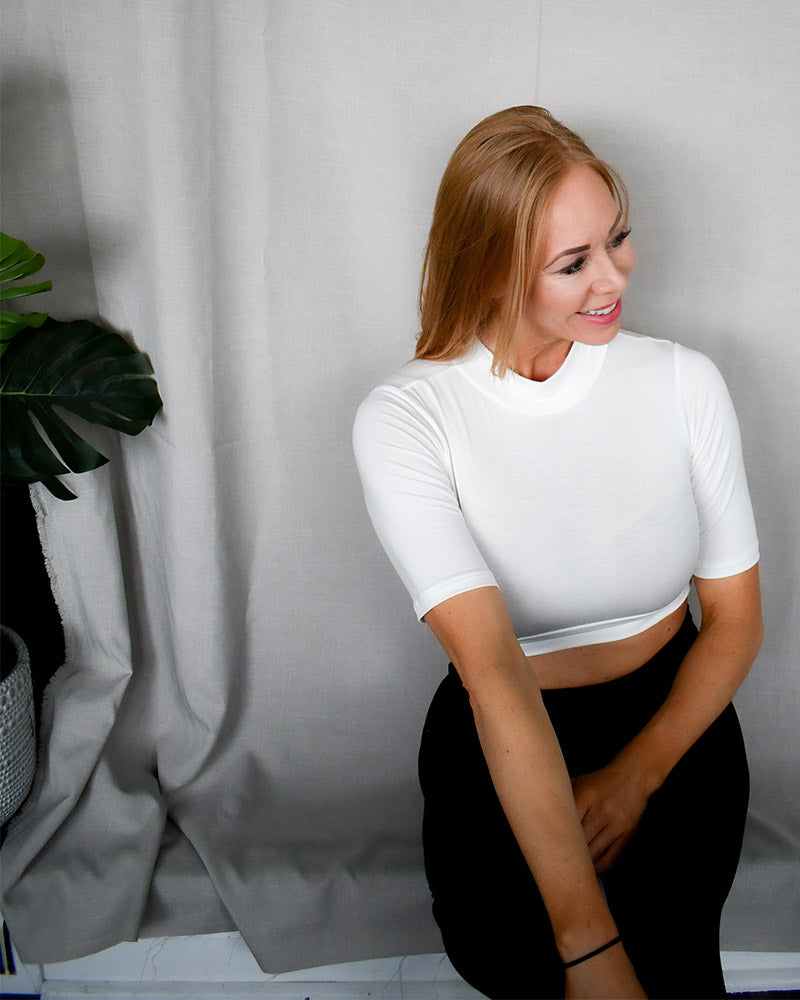 White crop top made from soft, breathable fabric. Mock Elbow Sleeve Halftee.
