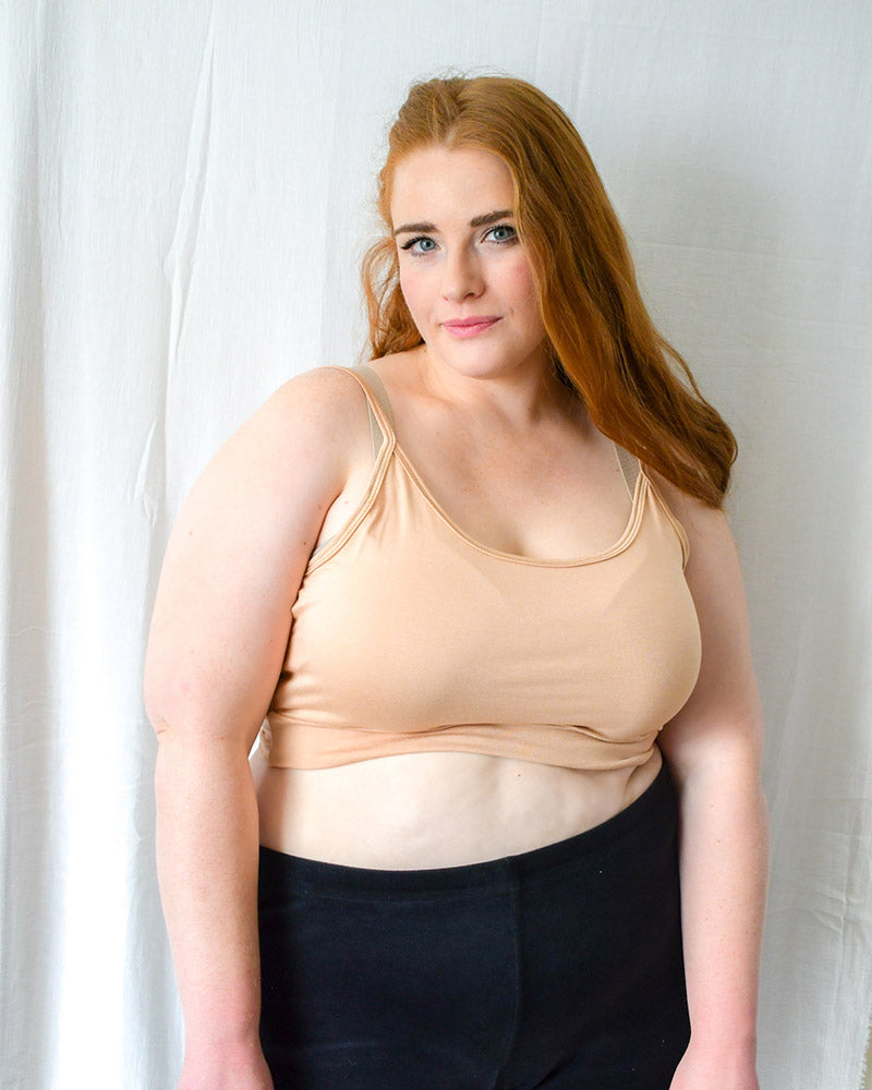 Woman in jeans and black crop top, wearing  nude Spaghetti Strap Halftee.