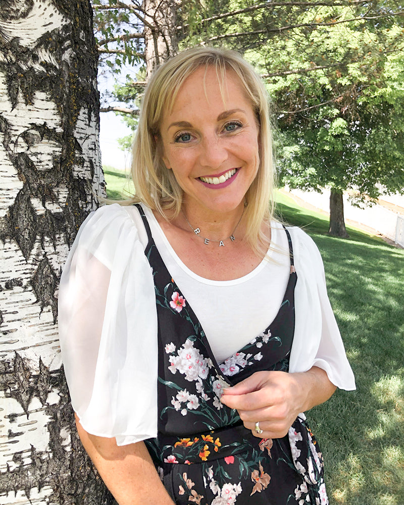A woman wearing a white top and black inner floral