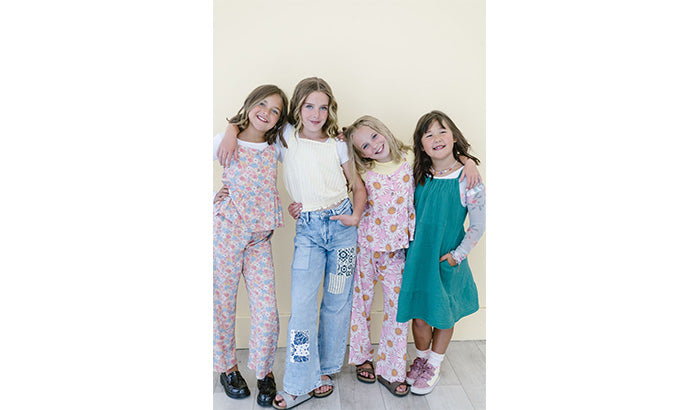 Four young girls in matching outfits posing for the camera, showcasing Girlees' stylish summer style for kids.