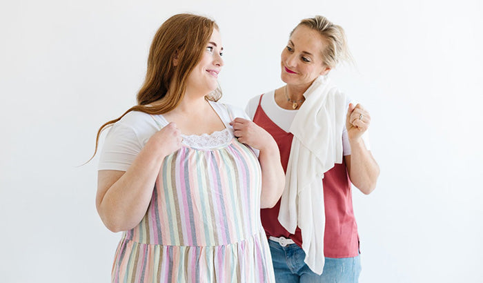 Two women wearing layered skirts, a cap sleeve shirt, and a tank top with pockets, standing against a white background.