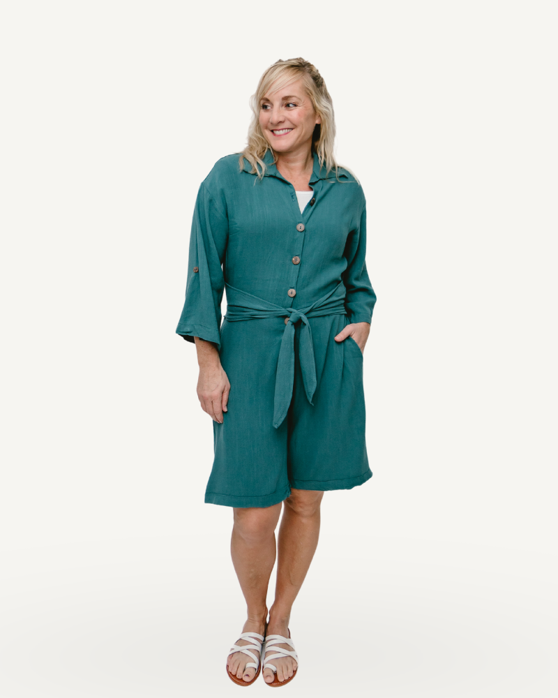A Green linen romper with long sleeves and a tie waist. Perfect for a casual summer look.