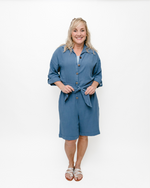 A Blue  linen romper with long sleeves and a tie waist. Perfect for a casual summer look.