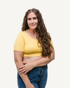 curly woman wearing yellow halftee and blue jeans