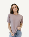  Woman in neutral shirt and jeans, standing confidently. Favorite Tee.