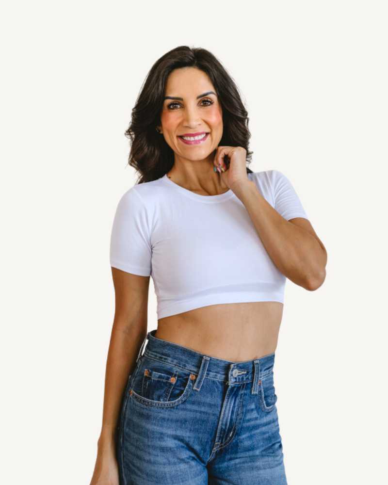 A woman wearing a white crop top and jeans, showcasing a Crew Neck Boyfriend Halftee.