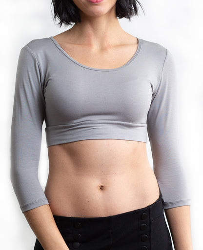 A woman wearing jeans and a crop top, showcasing The Classic 3/4 gray Sleeve Halftee - NEUTRALS.