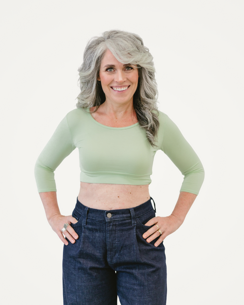 A woman with grey hair wearing a green crop top