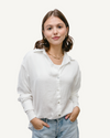 Woman in white satin button-down shirt and jeans.