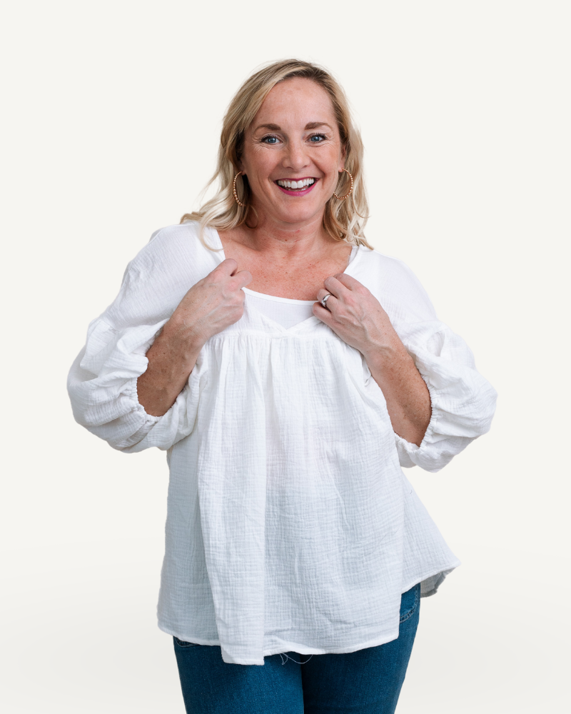 A woman wearing an white gauze babydoll top.