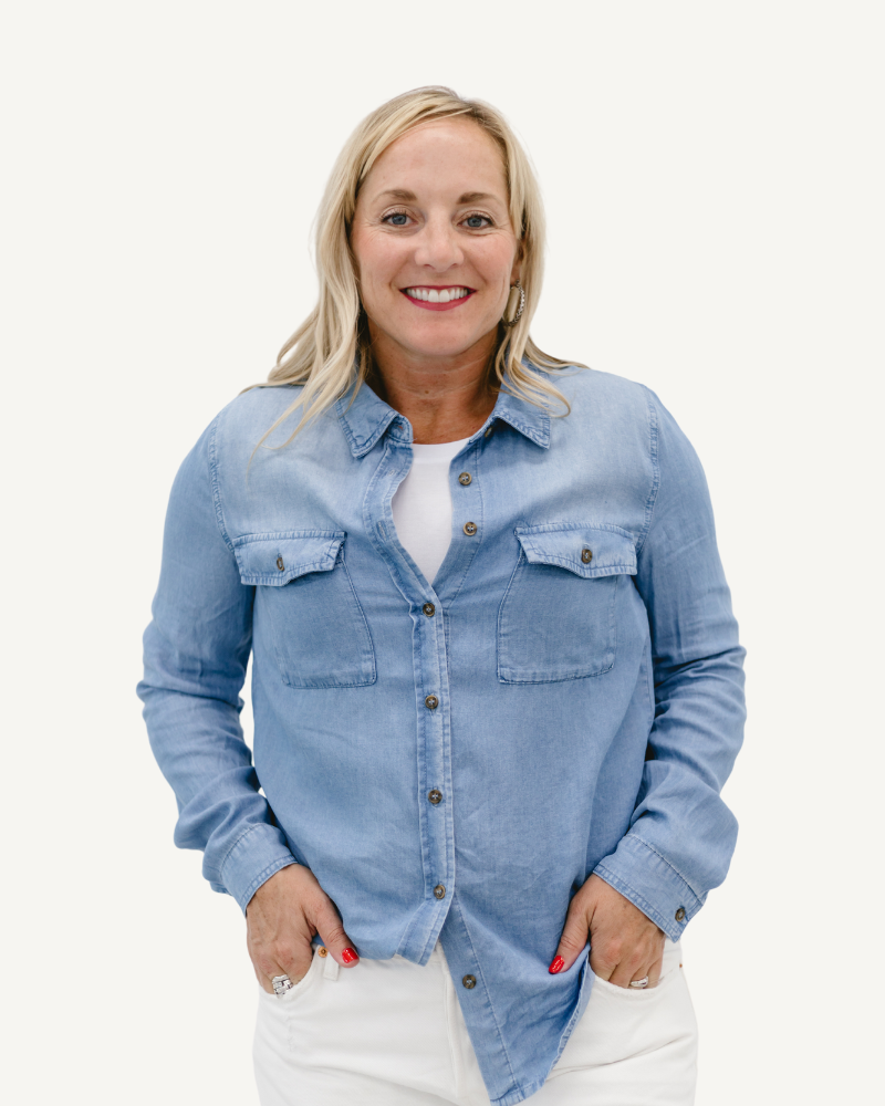 A girl wearing a denim shirt and white pants stands confidently, showcasing a casual yet stylish outfit.