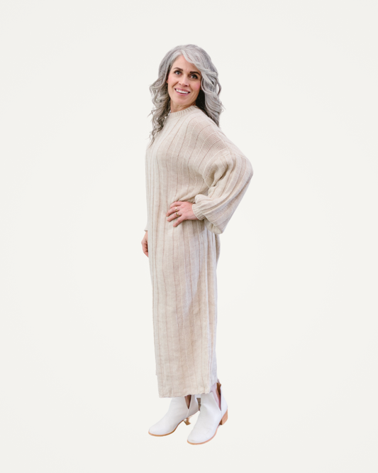 A woman is dressed in a chic long sweater dress