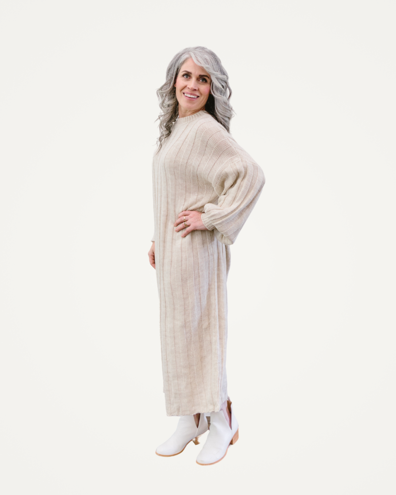 A woman is dressed in a chic long sweater dress