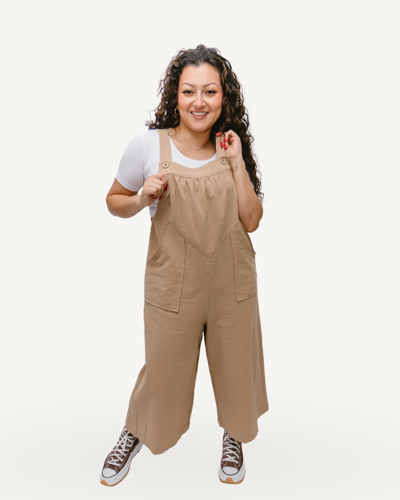 A woman in a cropped linen overall jumper striking a pose for the camera.