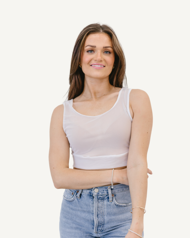 Woman in white mesh tank top and black leggings.