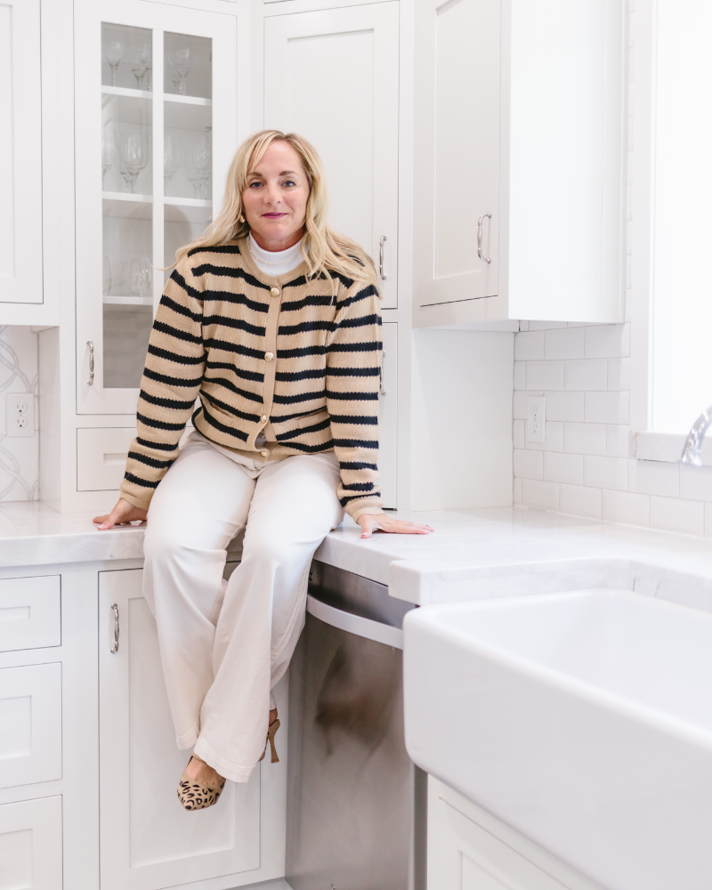 A woman comfortably seated on a kitchen counter.