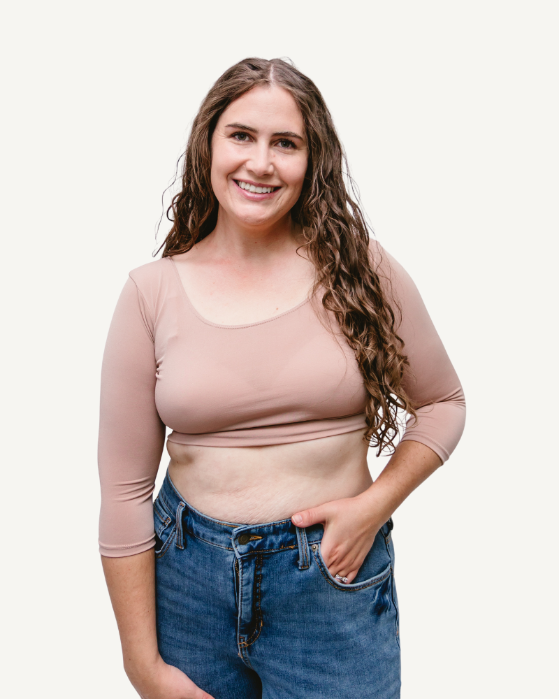 A woman wearing jeans and a taupe crop top with elbow sleeves and a V-neck.