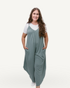 A woman wearing a green jumpsuit made of solid French Terry fabric, featuring wide legs.