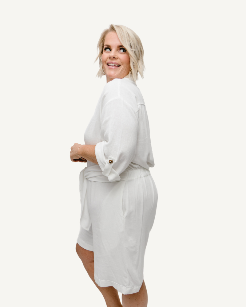A white linen romper with long sleeves and a tie waist. Perfect for a casual summer look.