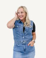 A young woman wearing a denim vest and jeans, exuding a casual and stylish vibe.