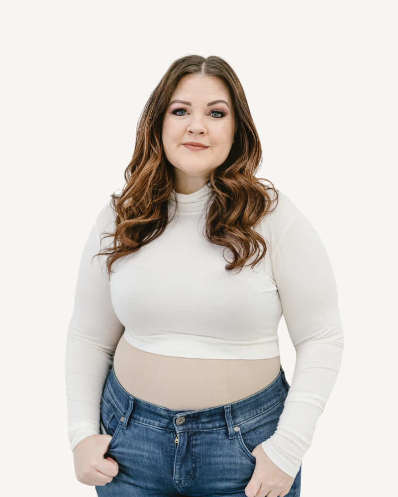 A woman wearing a white turtleneck long sleeve top and jeans.