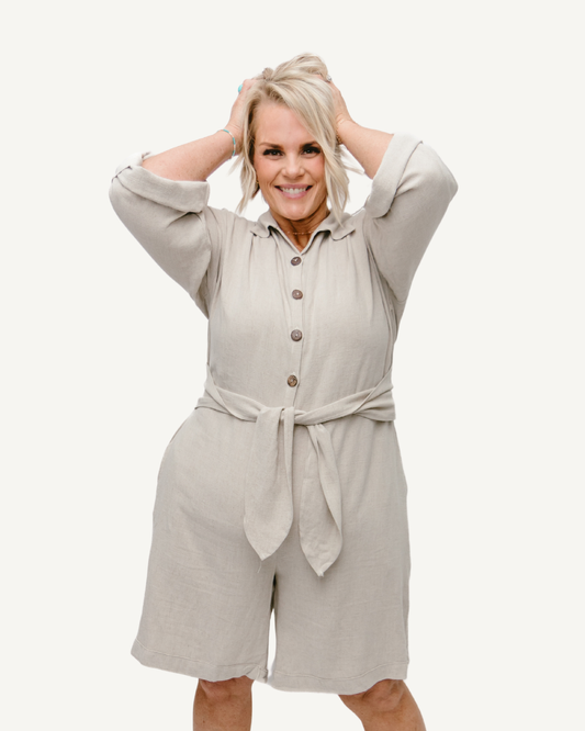 A Gray linen romper with long sleeves and a tie waist. Perfect for a casual summer look.