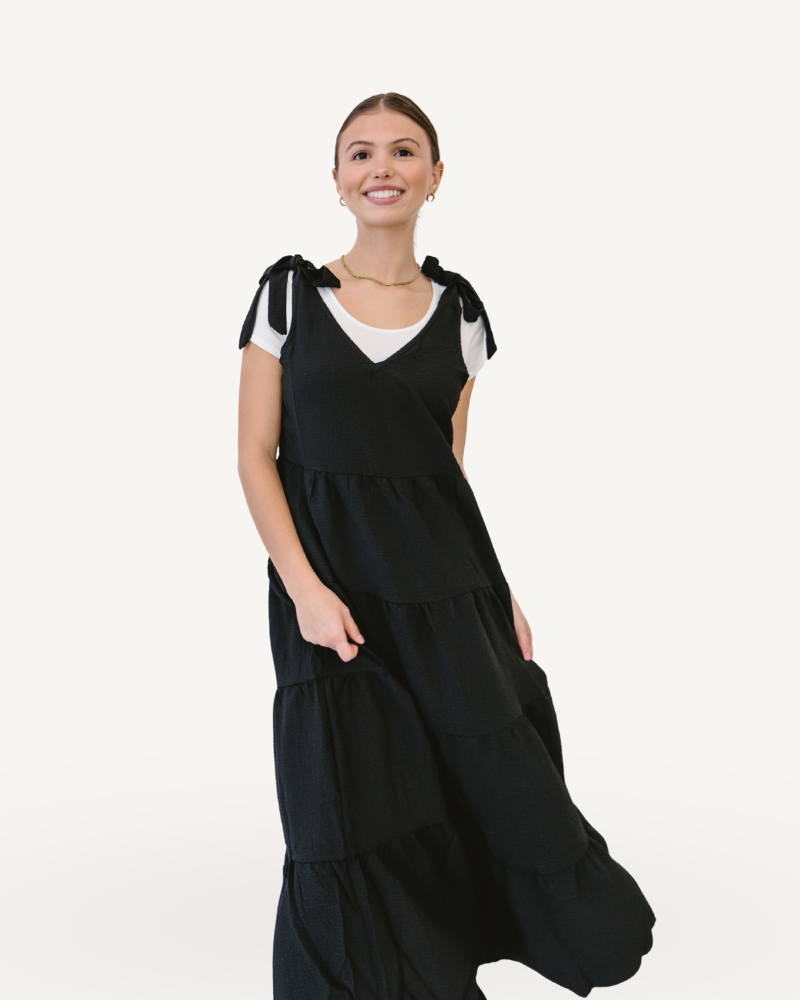 A ribbed knit maxi dress in black with tiered design, perfect for a stylish and elegant look.