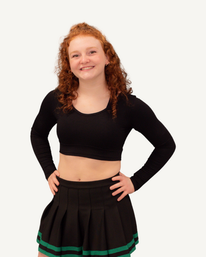 A woman wearing a white crop top and black shorts, showcasing the Brand New ATHLETIC Long Sleeve Halftee.