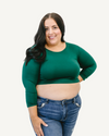 A plus size woman wearing a green crop top and jeans. (Discontinued 3/4 Colors)