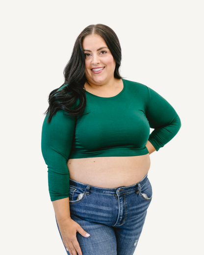 A plus size woman wearing a green crop top and jeans. (Discontinued 3/4 Colors)