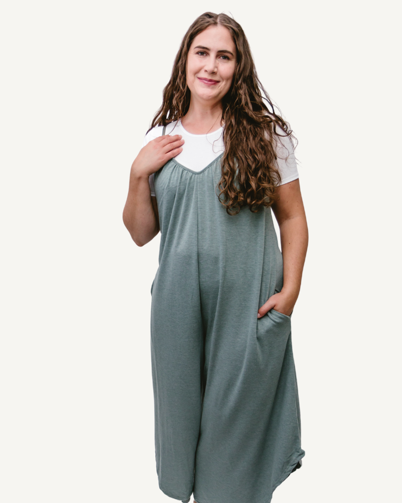 A woman wearing a green jumpsuit made of solid French Terry fabric, featuring wide legs.
