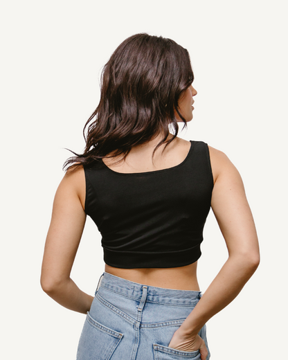 A woman wearing an Elegant Tank, seen from the back, in a black crop top.