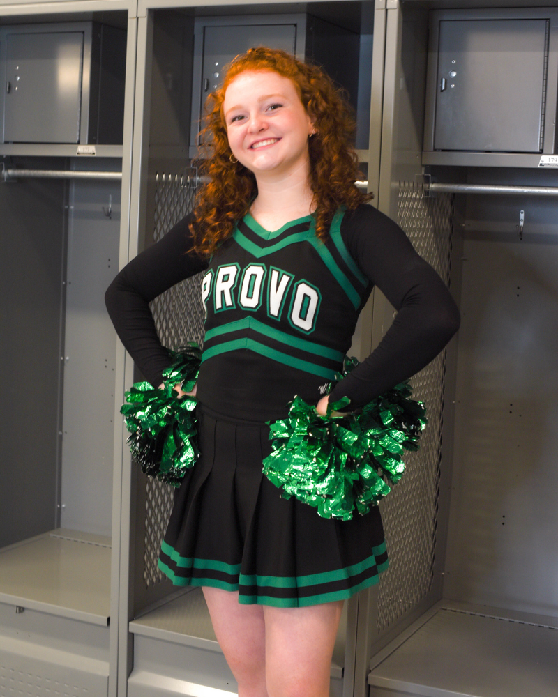 A woman wearing a black with green crop top and black shorts, showcasing the Brand New ATHLETIC Long Sleeve Halftee.