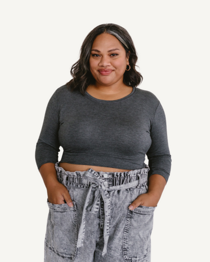 A plus size woman wearing a gray  crop top and jeans. (Discontinued 3/4 Colors)
