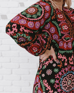 a girl wearing a pattern dress in a side view