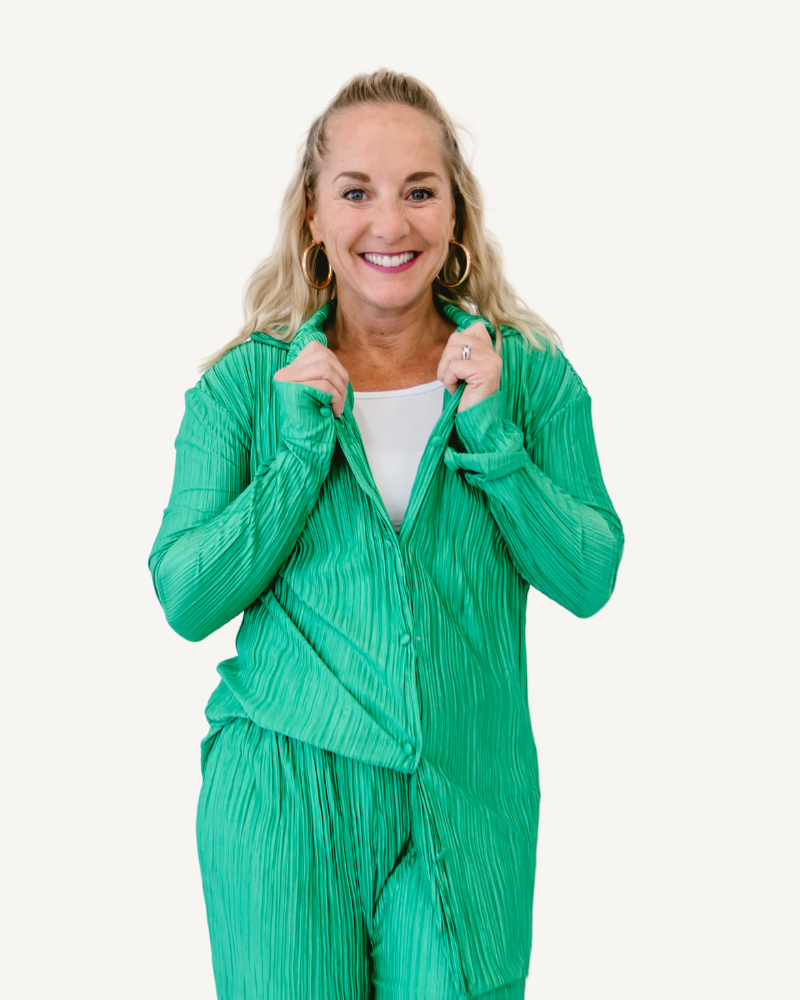Woman in green pajamas walking on white background. Oversized Pleated Shirt & Pant Set.