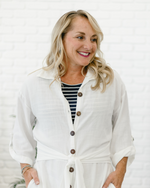 woman wearing white dress button with black stripe shirt inside