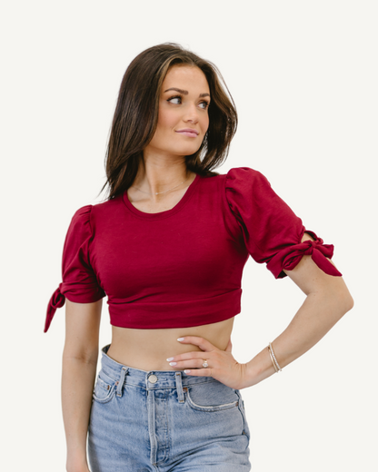 woman in a neon red top and jeans, wearing a Puff Sleeve Halftee with Tie Detail.