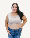 A curvy woman in a nude crop top and jeans, wearing a Peekaboo Short Sleeve Halftee with lace inset.