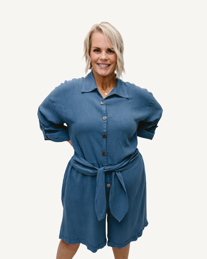 A Blue  linen romper with long sleeves and a tie waist. Perfect for a casual summer look.