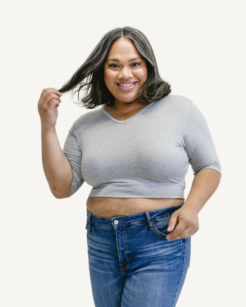 A woman wearing a gray top and jeans.