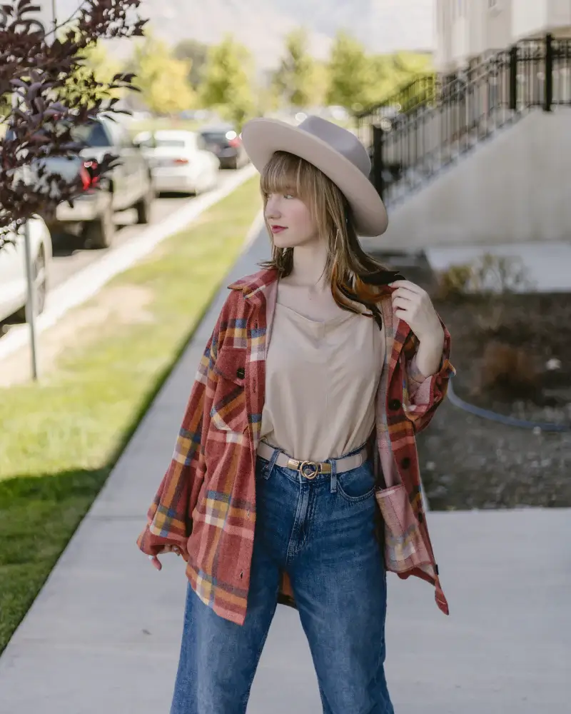 a girl wearing hat and brown jacket and halftee shirt